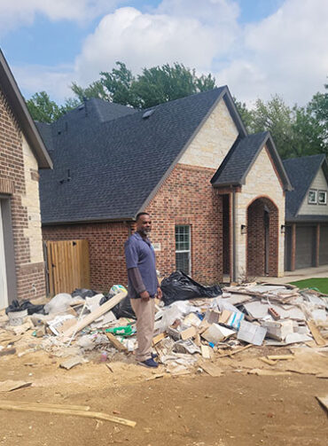 Workers handling large furniture removal from a house.